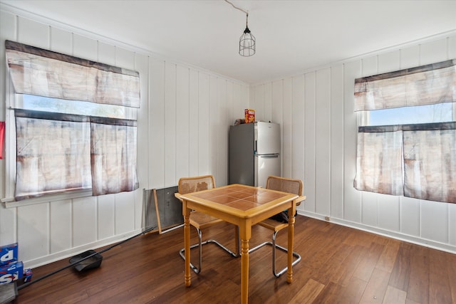 dining room featuring wooden walls and dark hardwood / wood-style floors