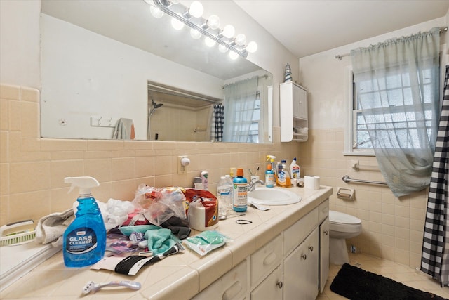 bathroom featuring tile patterned flooring, vanity, toilet, and tile walls