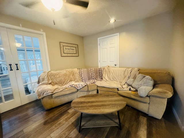 living room with dark wood-type flooring, ceiling fan, and french doors