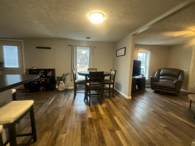 dining area featuring dark hardwood / wood-style flooring and a textured ceiling