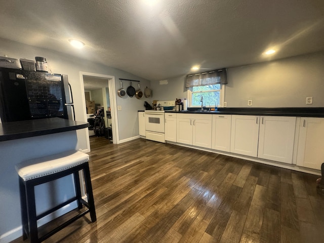 kitchen with dark hardwood / wood-style floors, white electric stove, sink, white cabinets, and fridge