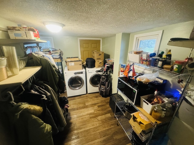 laundry area featuring hardwood / wood-style floors, washer and clothes dryer, and a textured ceiling