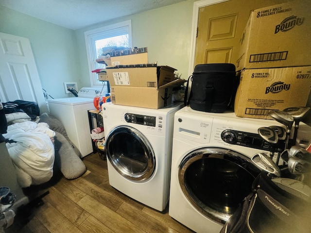 laundry area featuring washing machine and dryer and hardwood / wood-style floors