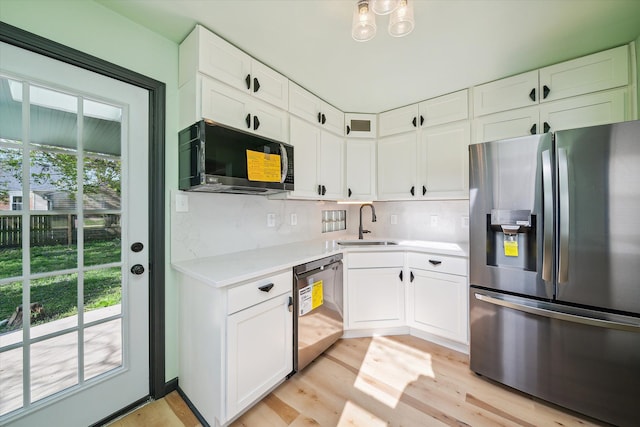 kitchen featuring sink, light hardwood / wood-style flooring, white cabinets, and appliances with stainless steel finishes