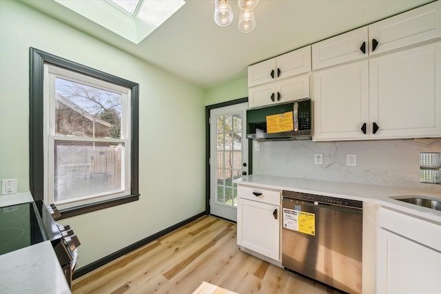 kitchen featuring white cabinetry, stainless steel appliances, a wealth of natural light, and a skylight