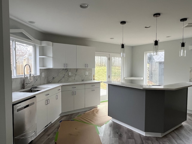 kitchen featuring pendant lighting, dishwasher, a center island, white cabinets, and sink