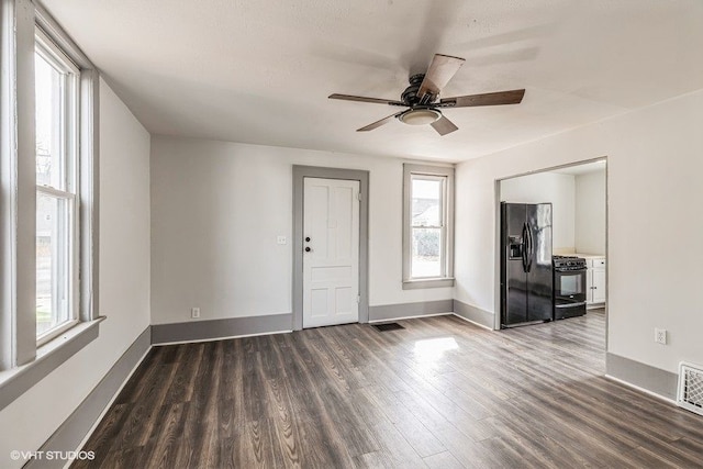 spare room featuring ceiling fan and dark wood-type flooring