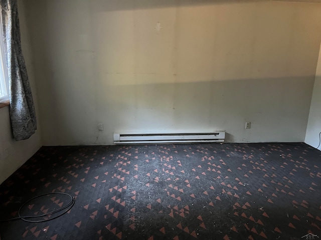 carpeted spare room with a baseboard radiator