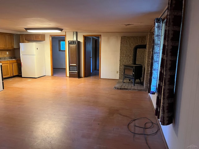 interior space with light hardwood / wood-style floors and a wood stove