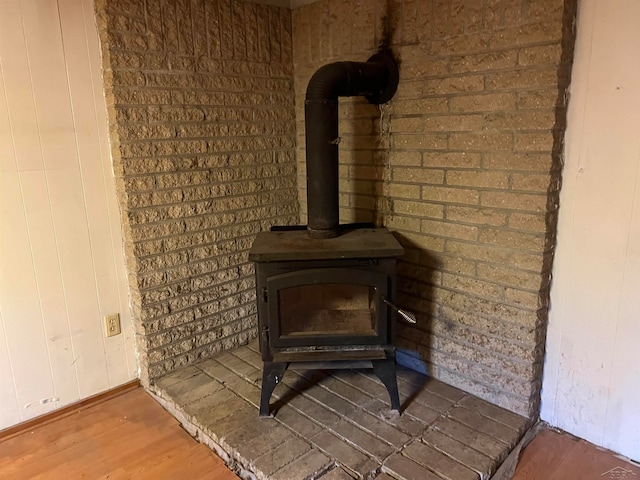 room details featuring hardwood / wood-style floors and a wood stove