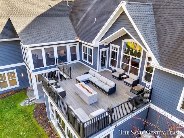 rear view of property featuring an outdoor living space with a fire pit