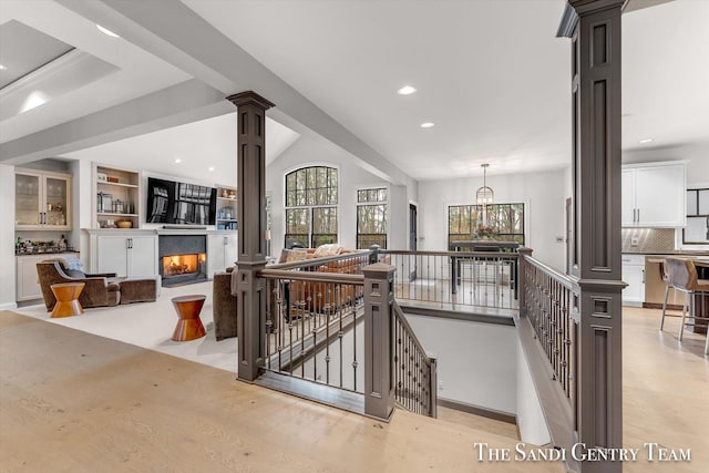 interior space with hardwood / wood-style floors, a chandelier, and decorative columns