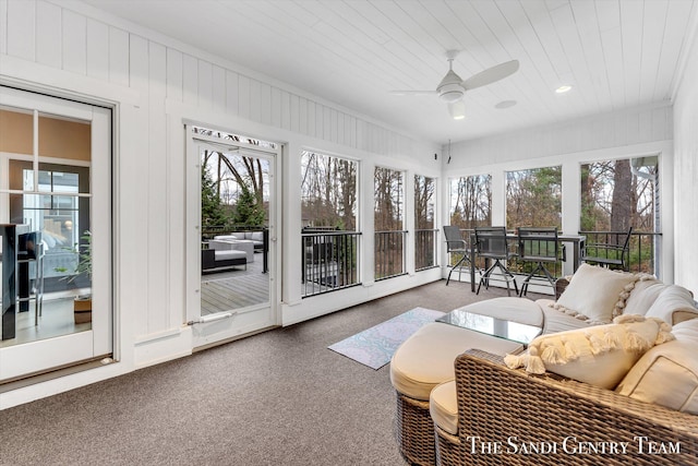 sunroom featuring baseboard heating, ceiling fan, and plenty of natural light