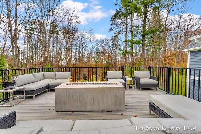 deck with an outdoor living space with a fire pit