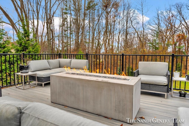 wooden terrace with an outdoor living space with a fire pit