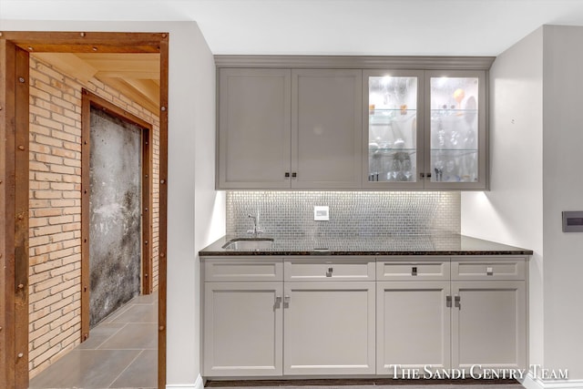 kitchen with decorative backsplash, sink, and dark stone counters