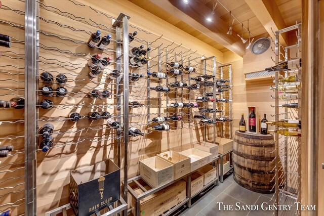 wine cellar featuring beam ceiling and tile patterned flooring