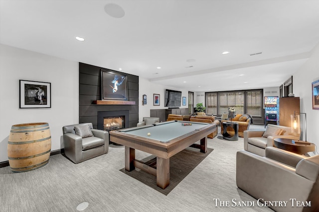 recreation room with a large fireplace and light carpet