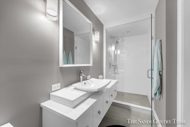 bathroom featuring tile patterned flooring, vanity, and a shower with door