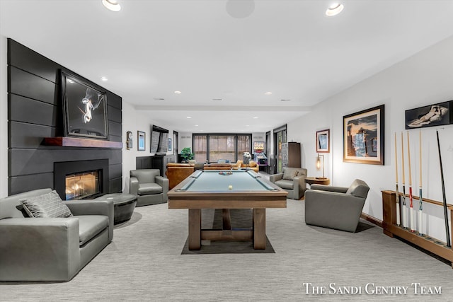 game room with a large fireplace, light colored carpet, and pool table