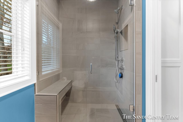 bathroom featuring a shower with door