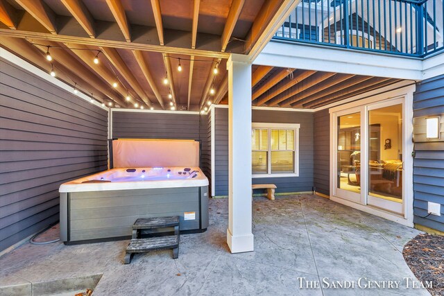 view of patio / terrace with washer / dryer, a balcony, and a hot tub