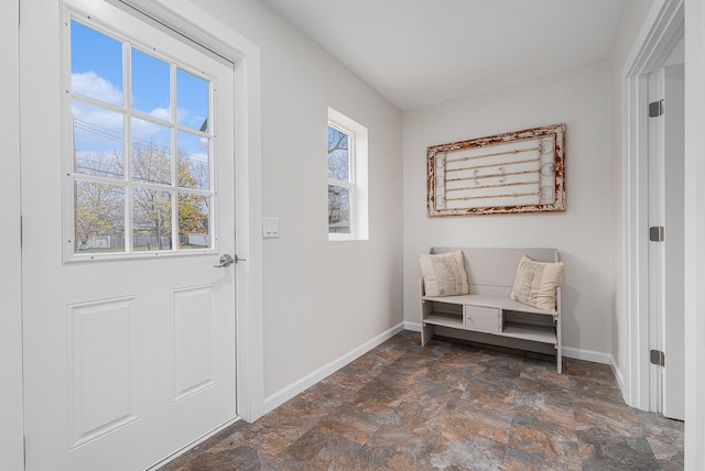 interior space with a wealth of natural light, stone finish floor, and baseboards