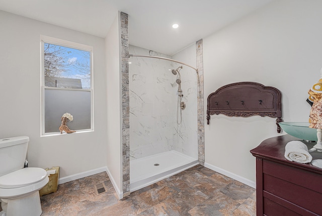 bathroom featuring toilet and tiled shower