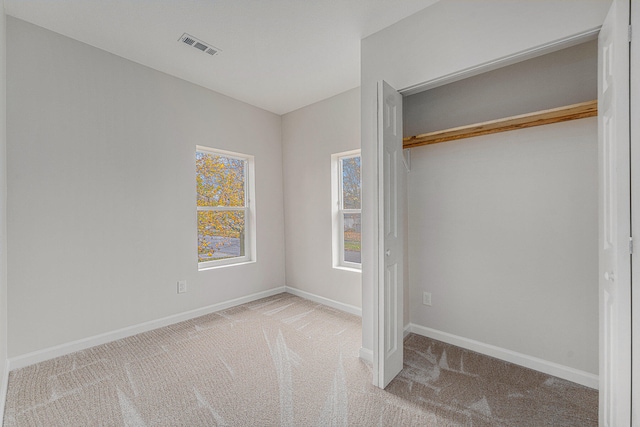 unfurnished bedroom with a closet and carpet flooring