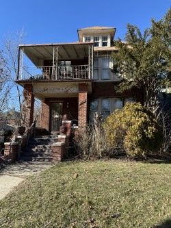 view of front of house featuring a balcony and a front yard