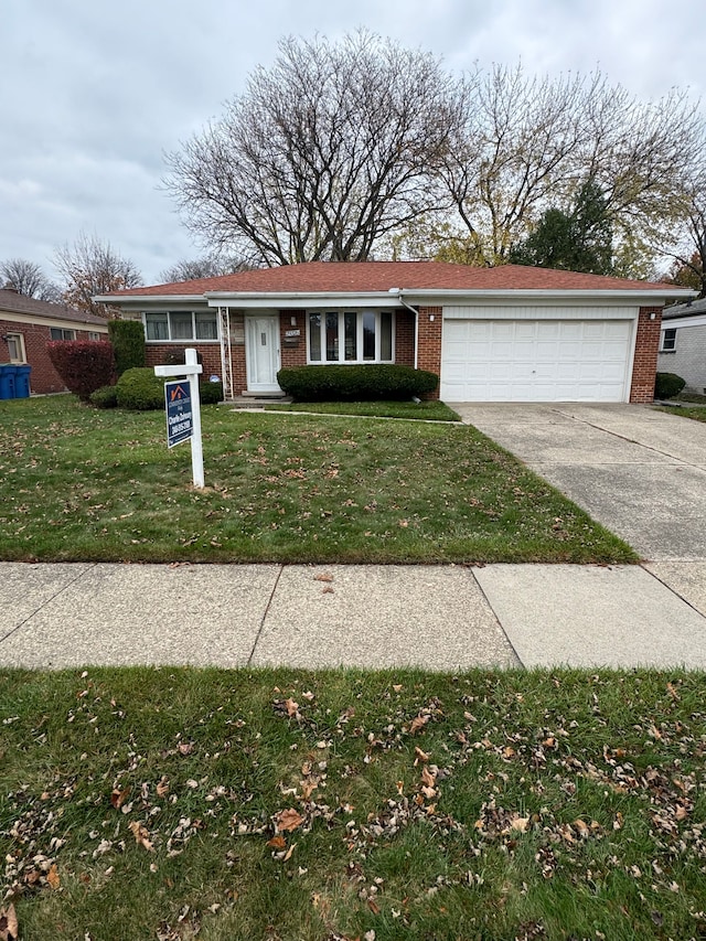 ranch-style home featuring a garage and a front lawn