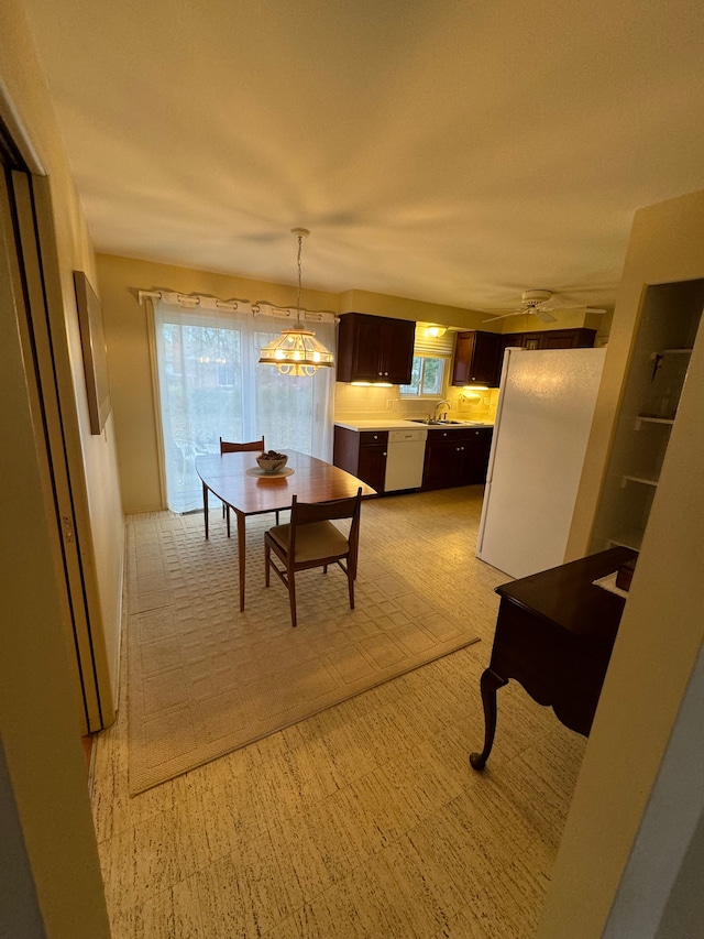 carpeted dining room featuring ceiling fan and sink