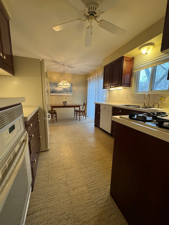 kitchen featuring decorative backsplash, white appliances, ceiling fan, sink, and hanging light fixtures