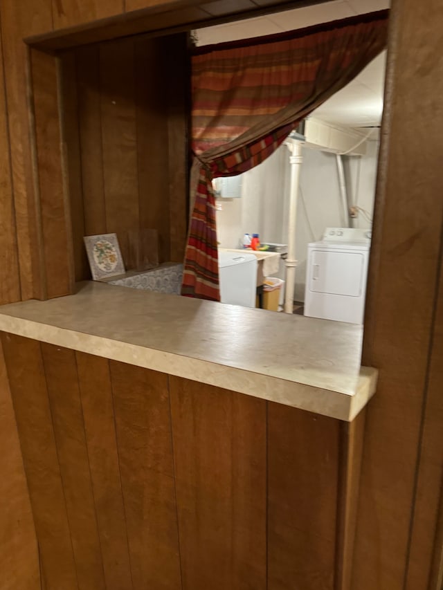 interior space featuring wood walls, sink, and washer / clothes dryer