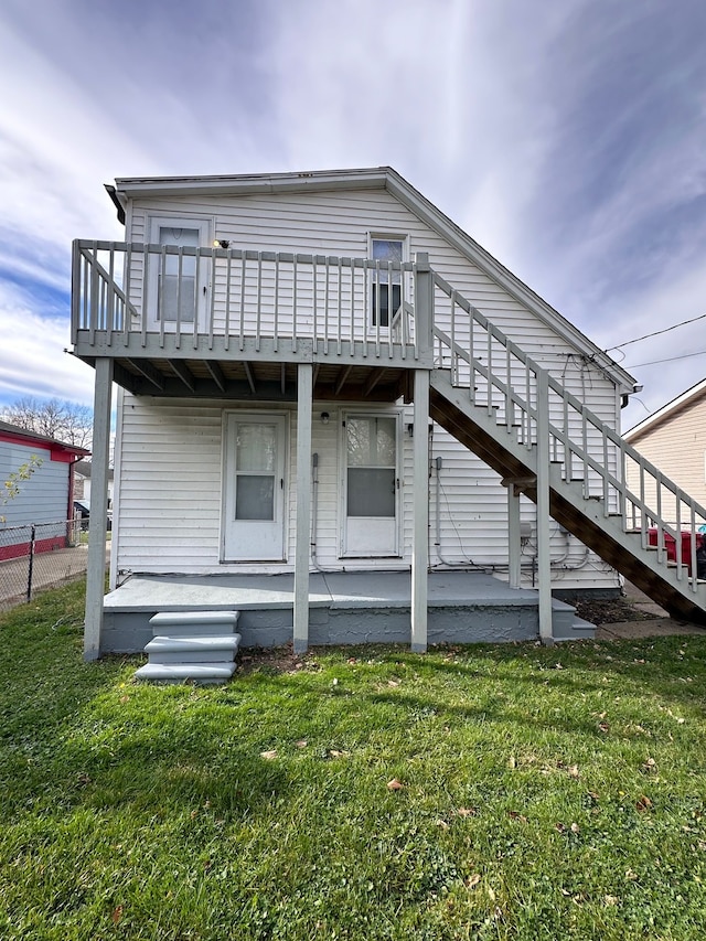 rear view of house featuring a patio, a deck, and a lawn