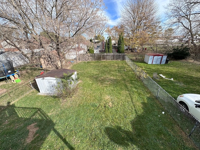 view of yard featuring a trampoline and a storage shed