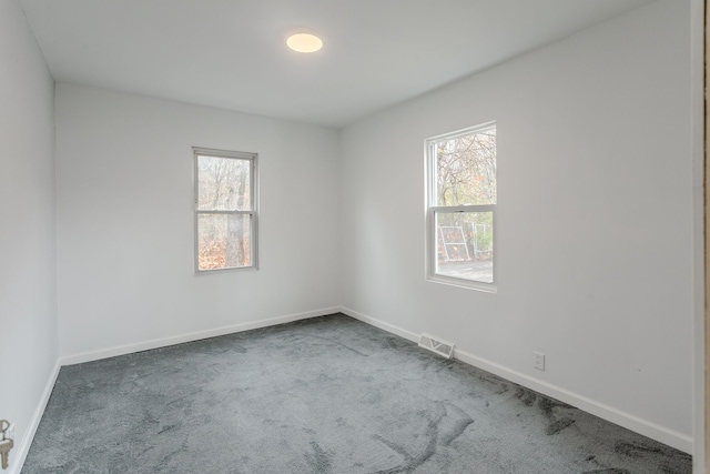 spare room featuring dark carpet