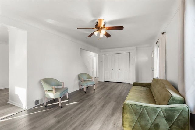 sitting room with ceiling fan and wood-type flooring