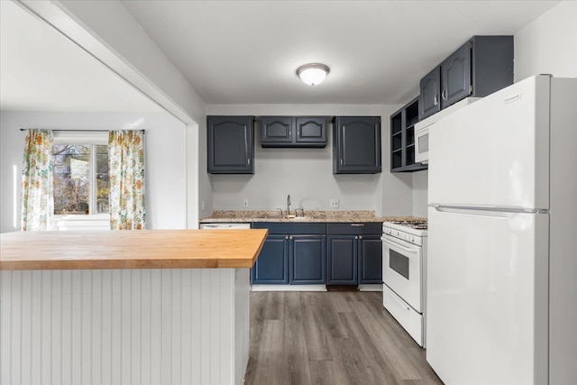 kitchen featuring wooden counters, white appliances, dark wood-type flooring, sink, and blue cabinetry