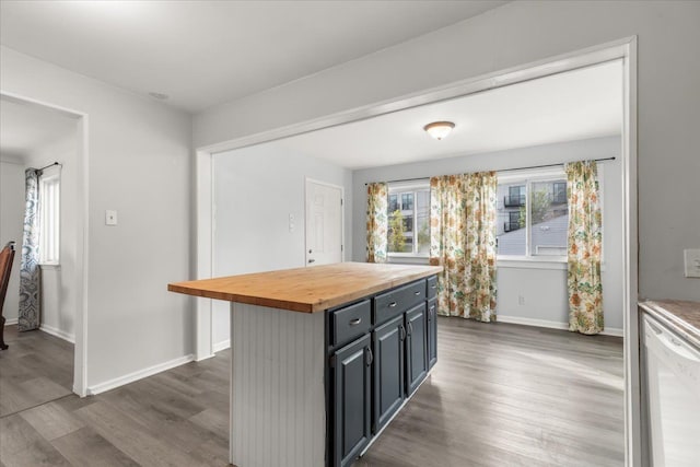 kitchen featuring dishwasher, a kitchen island, butcher block counters, and dark wood-type flooring