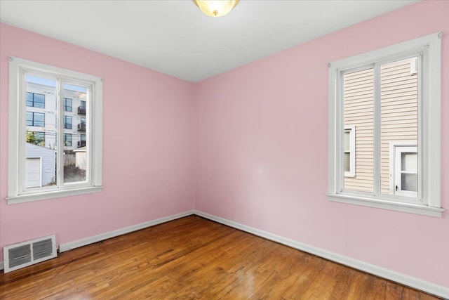 unfurnished room with hardwood / wood-style flooring and a wealth of natural light