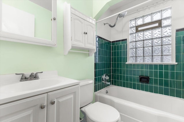 full bathroom featuring tiled shower / bath combo, toilet, and vanity