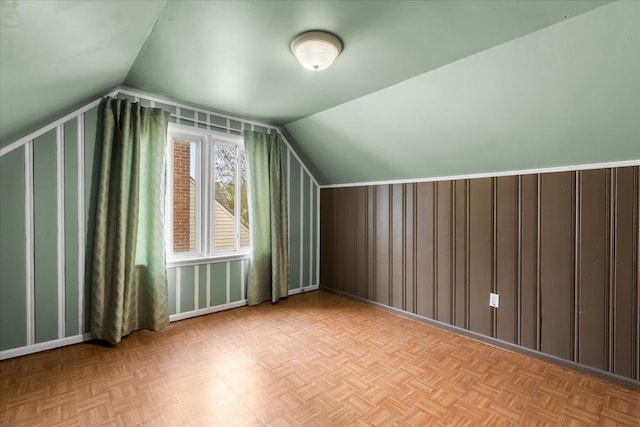 additional living space featuring light parquet flooring and lofted ceiling