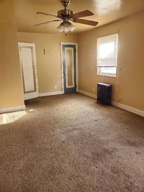 17366 Monica St, Detroit, MI 48221 - empty room with ceiling fan, radiator, and baseboards