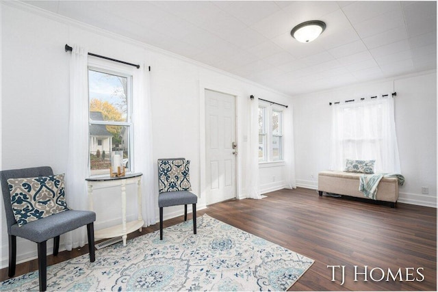 sitting room with dark hardwood / wood-style flooring and ornamental molding