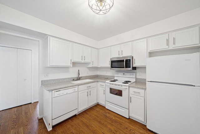 kitchen with a sink, light countertops, white cabinets, and white appliances