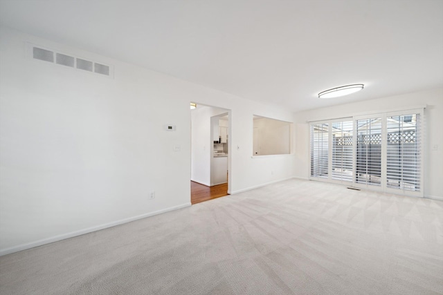 carpeted empty room with baseboards and visible vents