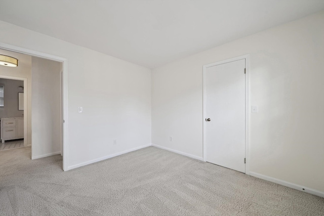spare room featuring baseboards and carpet