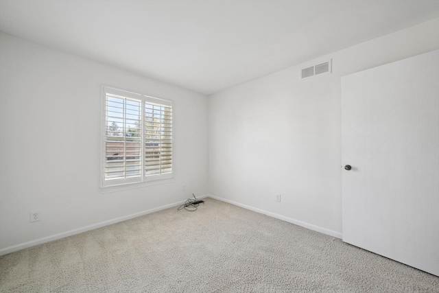 empty room featuring carpet floors, baseboards, and visible vents