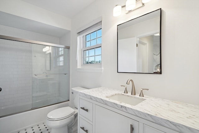 full bath featuring toilet, combined bath / shower with glass door, and vanity